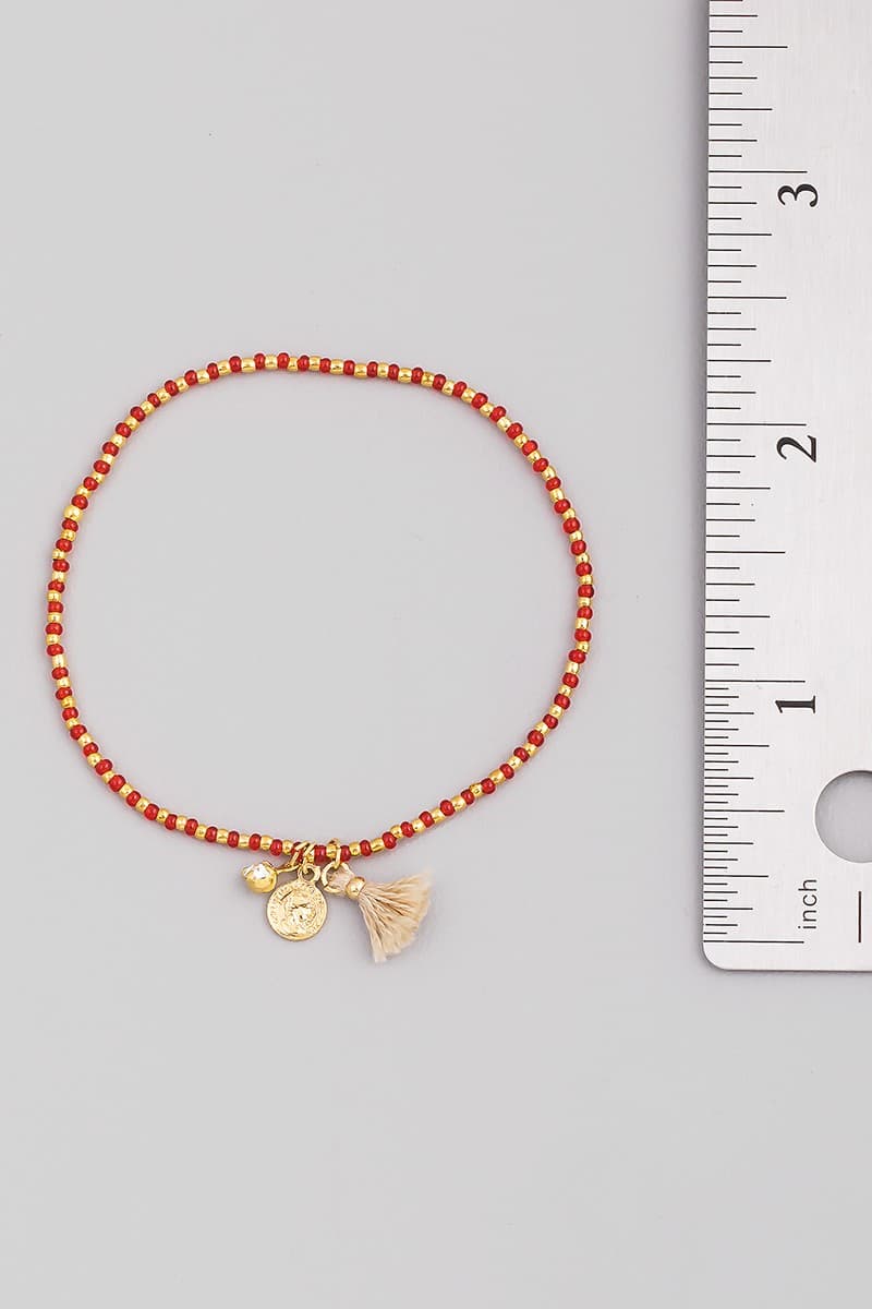 SEED BEAD STRETCH BRACELET WITH CHARM AND TASSEL