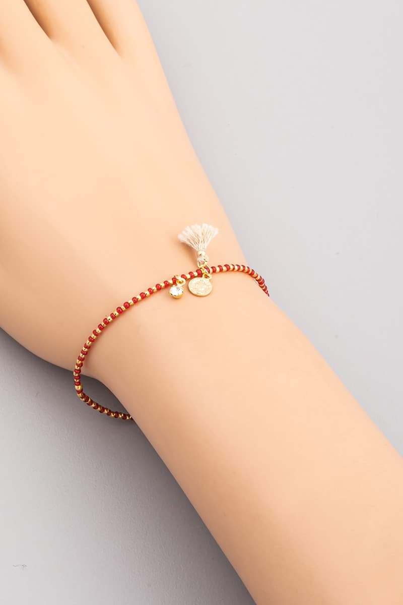 SEED BEAD STRETCH BRACELET WITH CHARM AND TASSEL